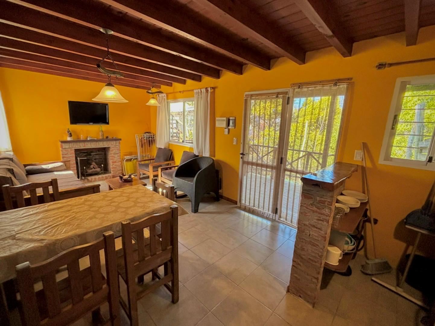 Living and dining room with wood fireplace and balcony access